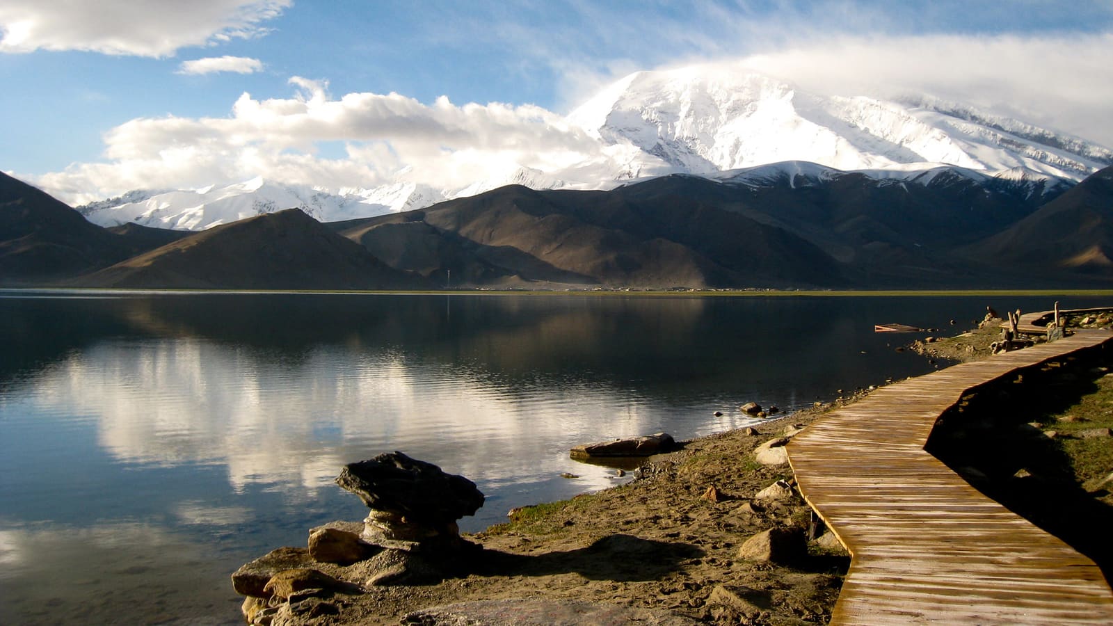 Lago di montagna dall'acqua limpida con passerella in legno