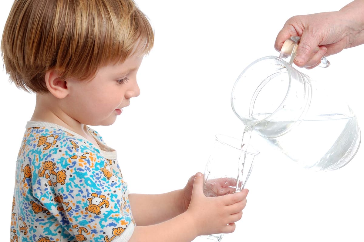 Bambino che riceve un bicchiere d'acqua potabile — potabilizzazione New Ecotecnica Sud